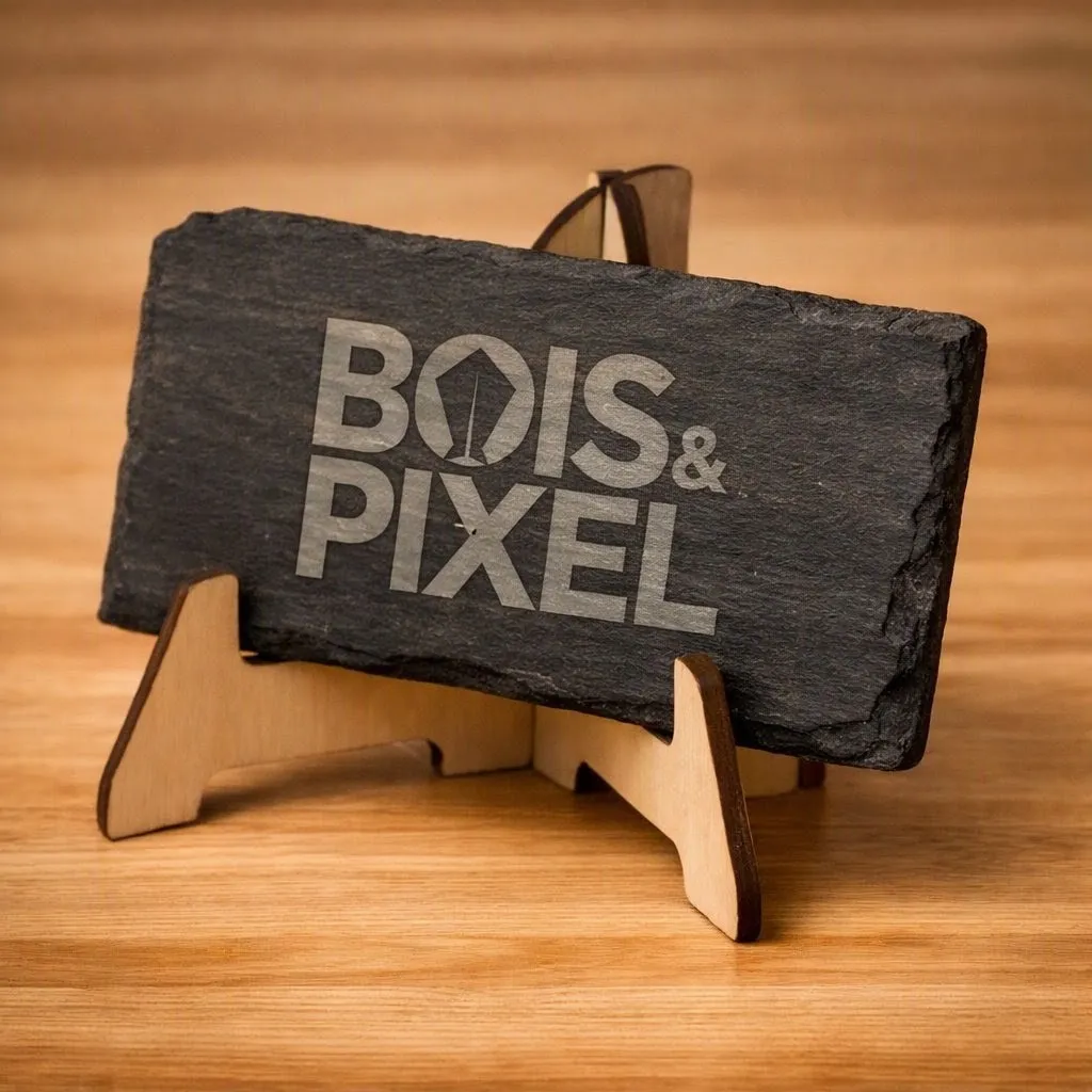 Plaque d'ardoise naturelle gravée au laser du logo Bois & Pixel, posée sur un chevalet en bois