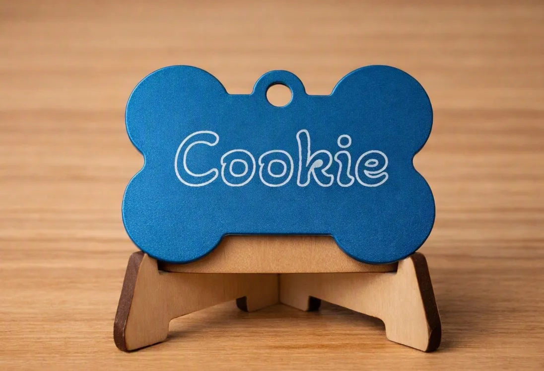 Médaille en aluminium bleu en forme d'os, gravée au prénom « Cookie »